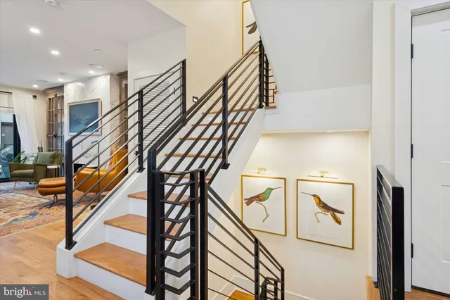 a hallway with wooden floor and staircase