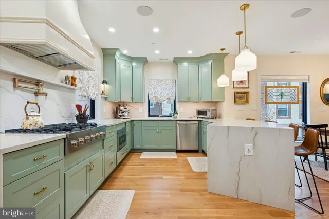 a kitchen with kitchen island granite countertop a sink a counter top space and cabinets