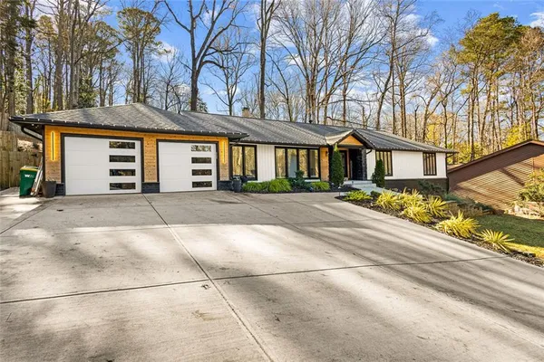 a front view of a house with a yard and trees