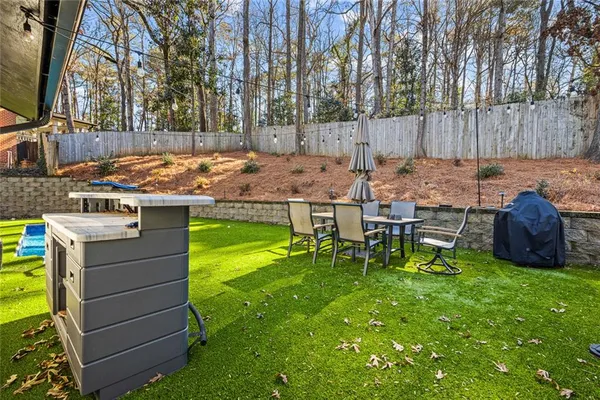 a large white kitchen with granite countertop a sink and dishwasher with a granite countertops next to a window