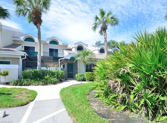 a front view of multi story residential apartment building with yard and entertaining space