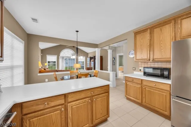 a large kitchen with kitchen island granite countertop a stove a sink dishwasher and white cabinets with wooden floor