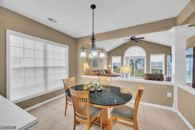 a dining room with furniture a chandelier and wooden floor