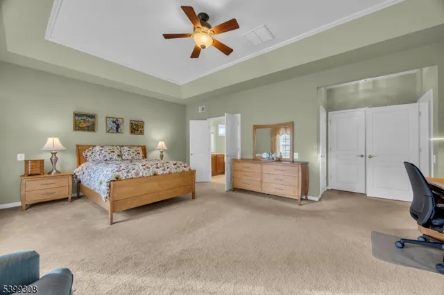 a spacious bedroom with a bed and a chandelier