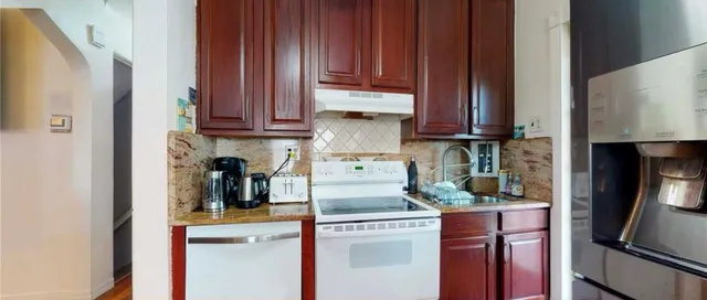 a kitchen with stainless steel appliances granite countertop a refrigerator and a sink