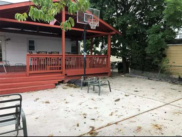 a view of a chair and table in backyard of the house