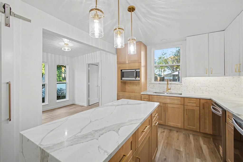 a kitchen with stainless steel appliances granite countertop a sink a stove and a window