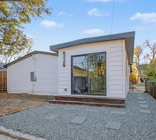 a view of a house with a yard and large tree