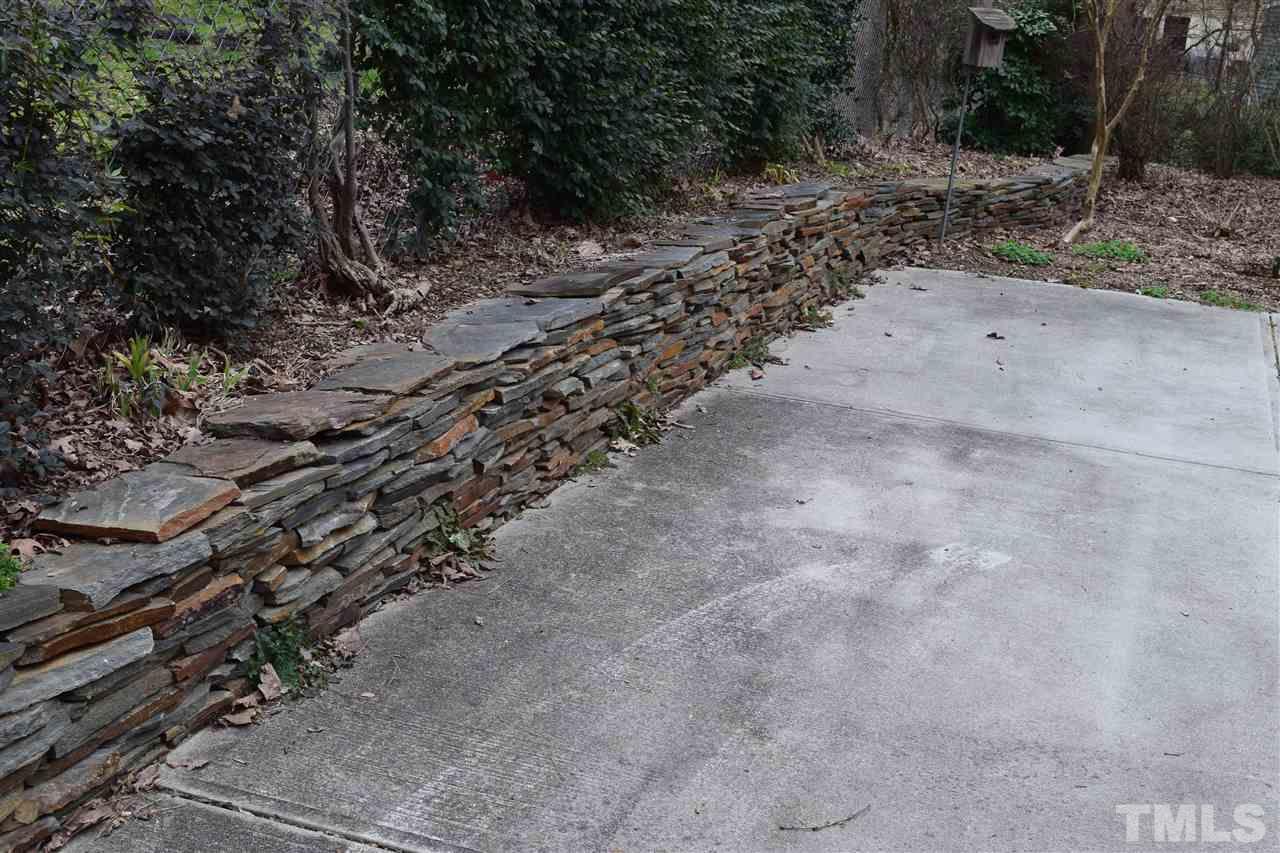 6908 Justice Drive Raleigh, NC 27615 - Photo 5 of 15 Stacked stone wall along the parking pad