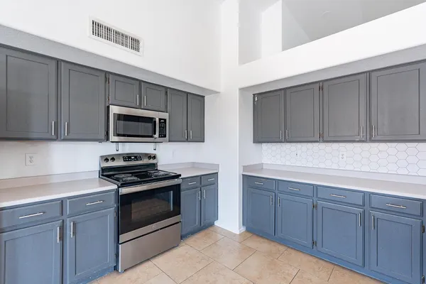 a kitchen with sink a microwave and cabinets