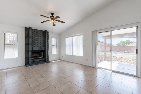 a view of an empty room with a fireplace and a window