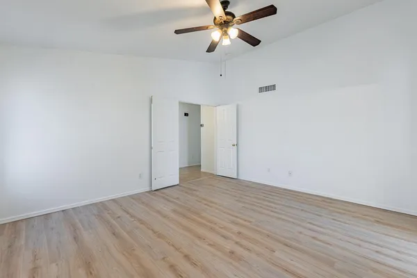 a view of an empty room with wooden floor