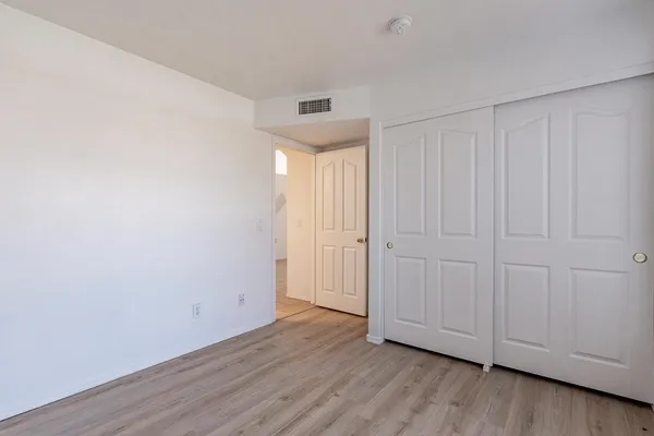 a view of an empty room with wooden floor