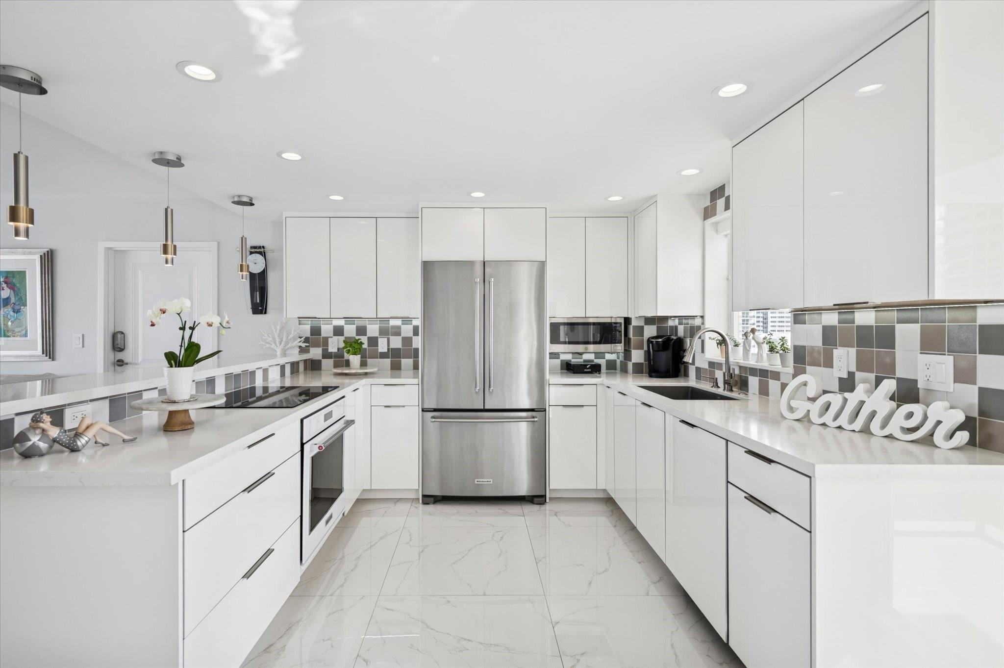 215 North Birch Road, Unit 8C Fort Lauderdale, FL 33304 - Photo 5 of 22 a kitchen with white cabinets and white appliances