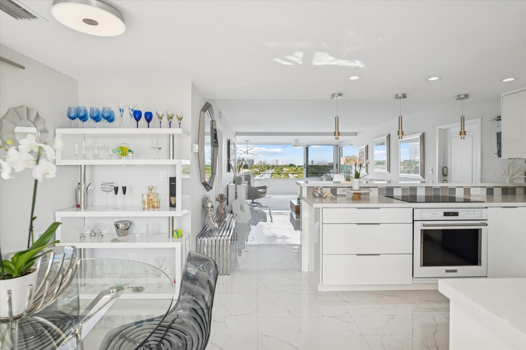 215 North Birch Road, Unit 8C Fort Lauderdale, FL 33304 - Photo 6 of 22 a kitchen with stainless steel appliances white cabinets and a couch