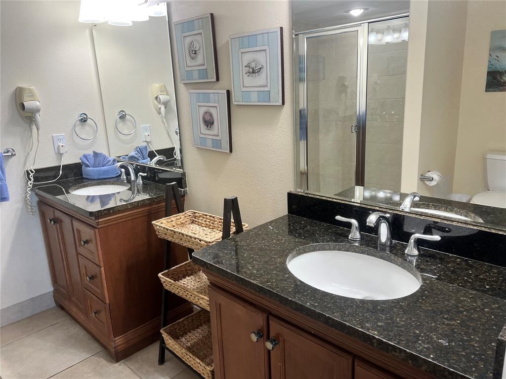 1001 Point Of Rocks Road, Unit 412 Sarasota, FL 34242 - Photo 19 of 43 a bathroom with a granite countertop sink a mirror and a toilet