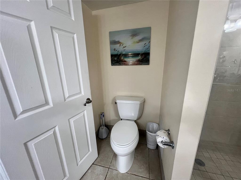 1001 Point Of Rocks Road, Unit 412 Sarasota, FL 34242 - Photo 21 of 43 a white toilet sitting next to a small wooden floor