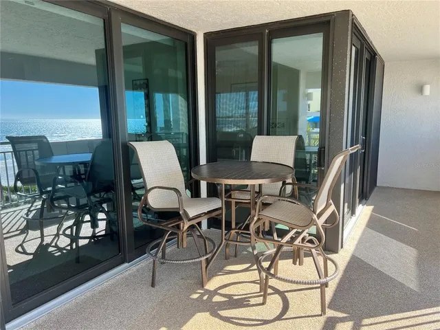 a dining room with furniture and a floor to ceiling window