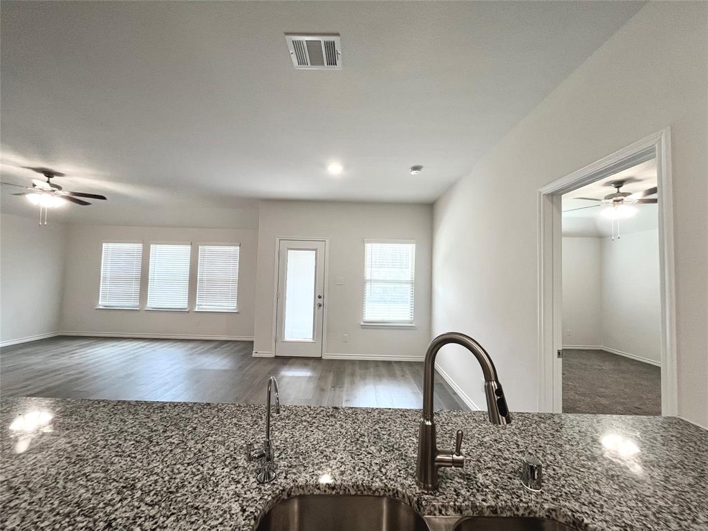 758 Musket Street Fate, TX 75189 - Photo 26 of 26 Kitchen featuring a ceiling fan, dark stone counters, wood finished floors, and open floor plan