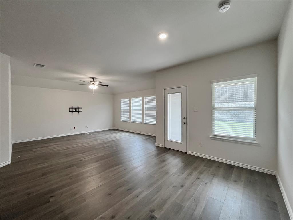 758 Musket Street Fate, TX 75189 - Photo 13 of 26 Unfurnished living room with ceiling fan and dark wood-style floors