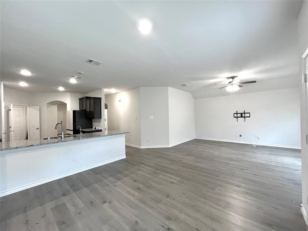 758 Musket Street Fate, TX 75189 - Photo 14 of 26 Unfurnished living room with arched walkways, ceiling fan, wood finished floors, and recessed lighting