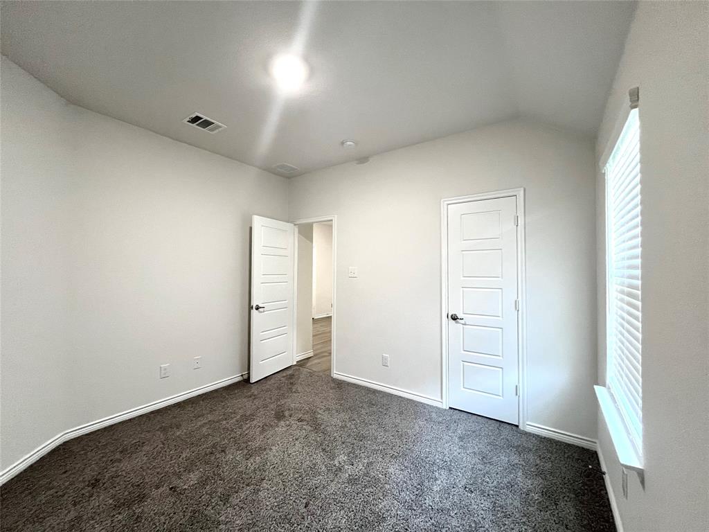 758 Musket Street Fate, TX 75189 - Photo 16 of 26 Unfurnished bedroom with dark carpet and vaulted ceiling
