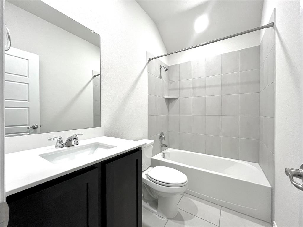 758 Musket Street Fate, TX 75189 - Photo 18 of 26 Bathroom with vanity, shower combination, lofted ceiling, and tile patterned floors