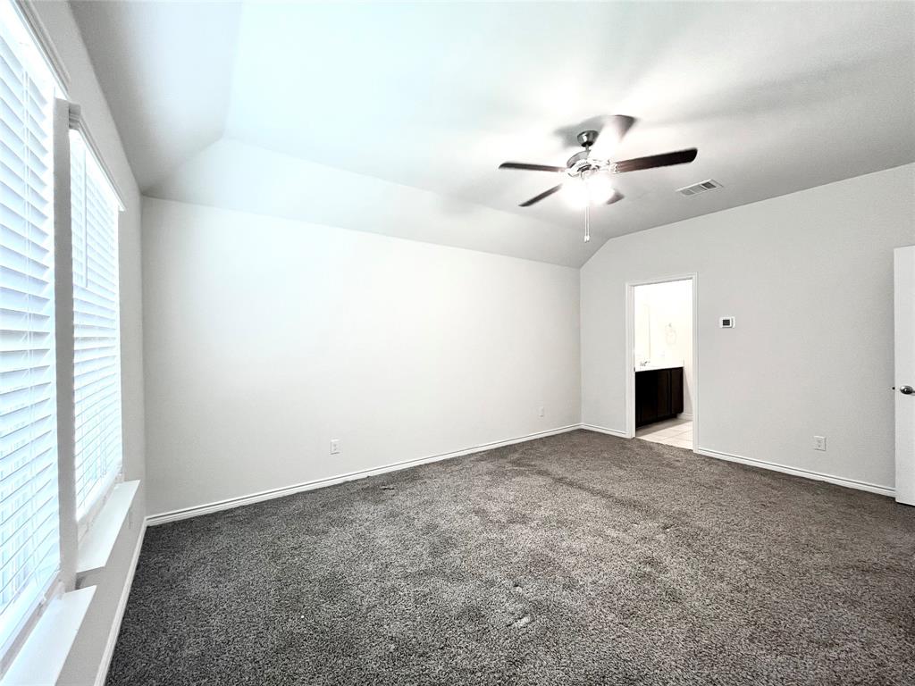 758 Musket Street Fate, TX 75189 - Photo 19 of 26 Spare room featuring ceiling fan, lofted ceiling, and carpet flooring
