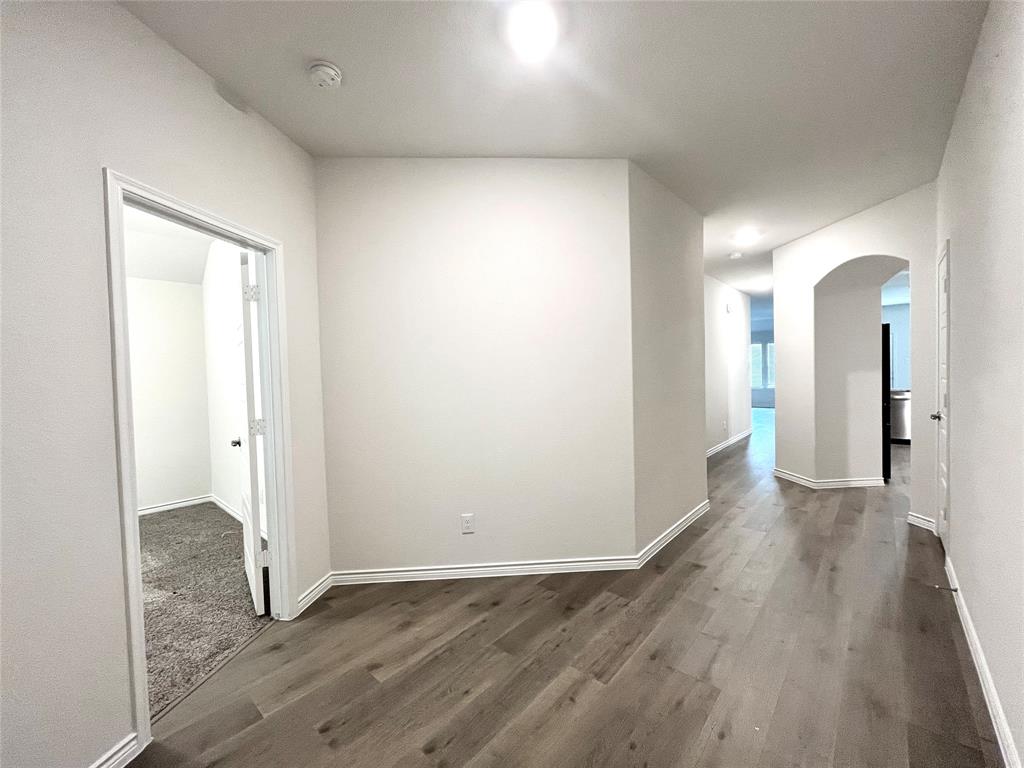 758 Musket Street Fate, TX 75189 - Photo 3 of 26 Corridor with arched walkways and wood finished floors