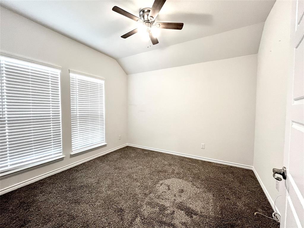758 Musket Street Fate, TX 75189 - Photo 4 of 26 Spare room featuring dark carpet, a ceiling fan, and vaulted ceiling