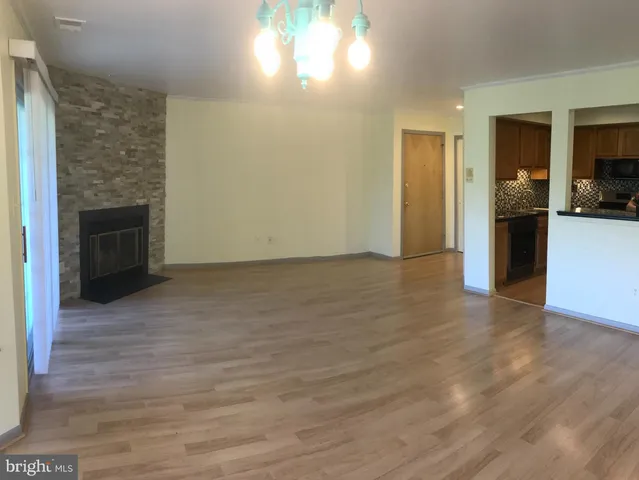 a view of empty room with kitchen and window