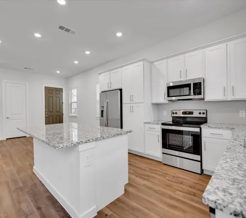 a kitchen with stainless steel appliances granite countertop a stove a sink and a microwave