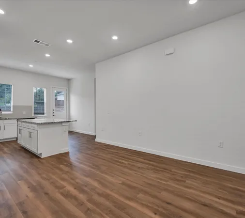 a large kitchen with wooden floor and a sink