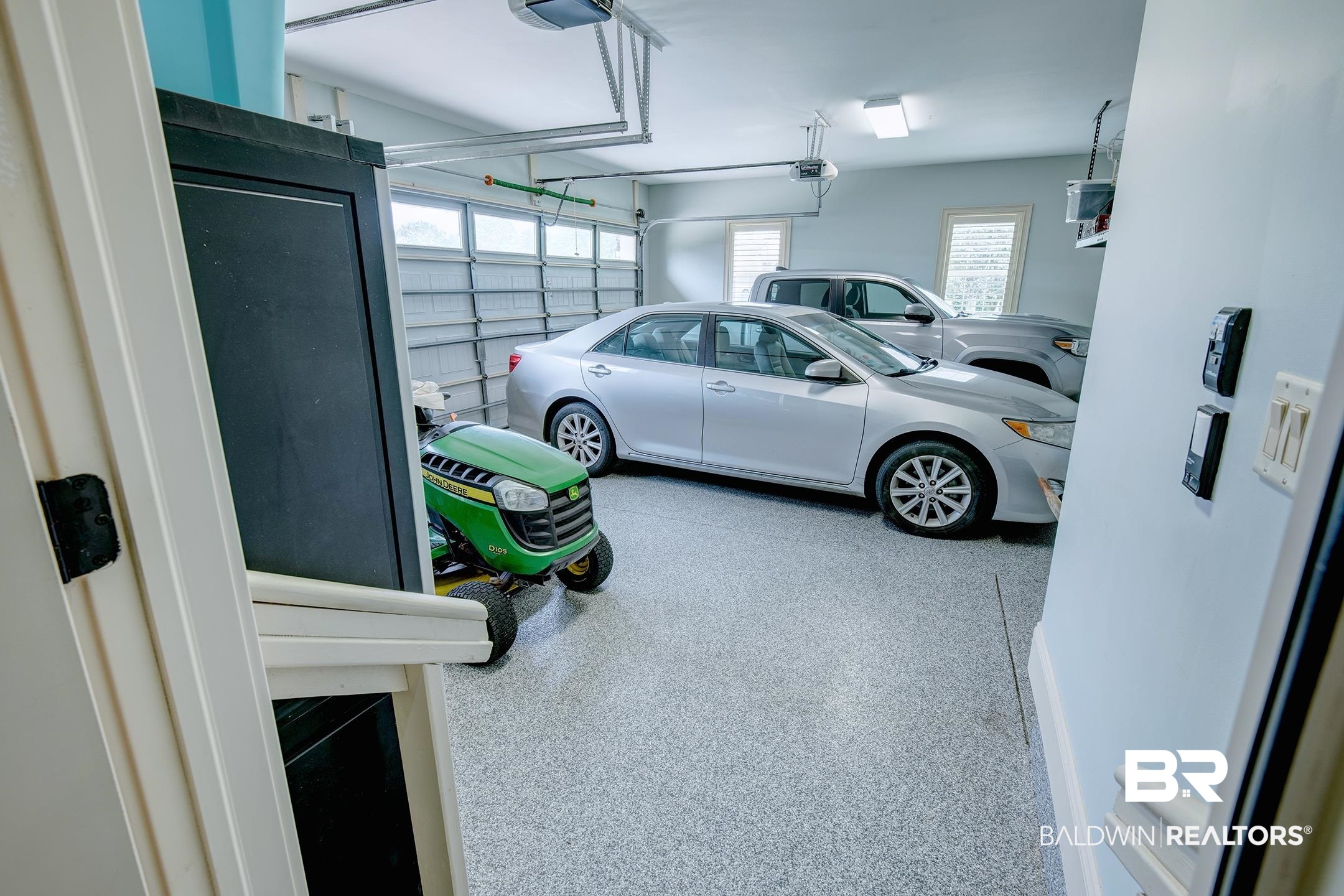 9357 Lakeview Drive Foley, AL 36535 - Photo 55 of 68 Spacious two-car garage featuring a speckled epoxy floor, multiple windows, and two overhead garage doors with automatic openers