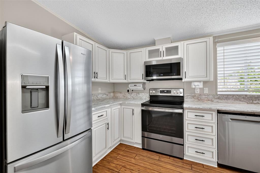 3024 Manatee Road Tavares, FL 32778 - Photo 11 of 39 a kitchen with granite countertop a stove microwave and refrigerator