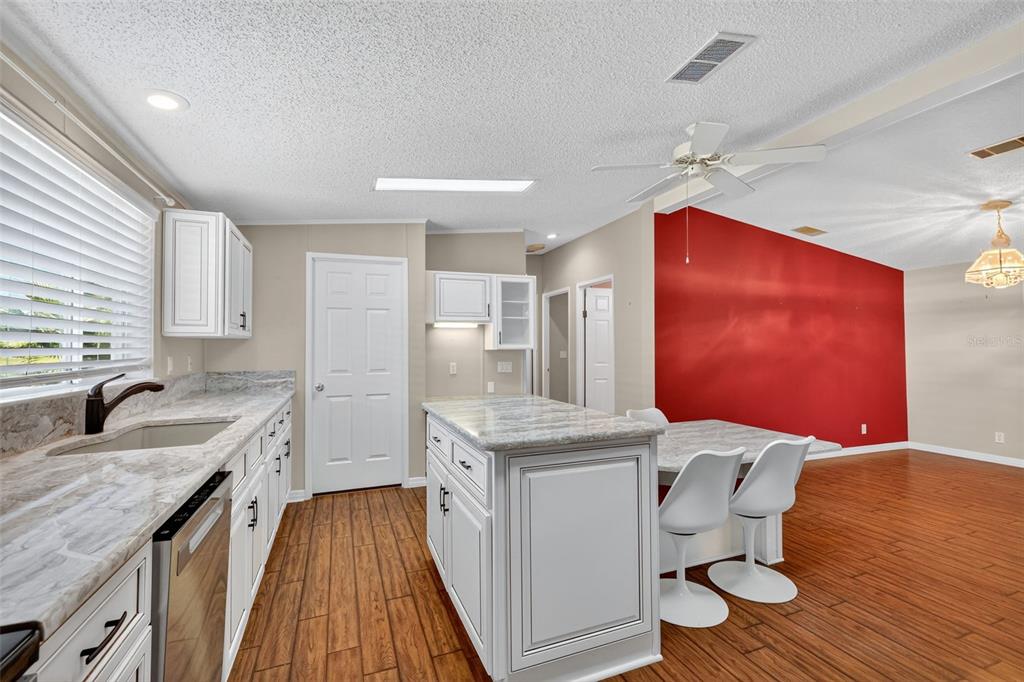 3024 Manatee Road Tavares, FL 32778 - Photo 12 of 39 a kitchen with granite countertop cabinets a sink a window and stainless steel appliances