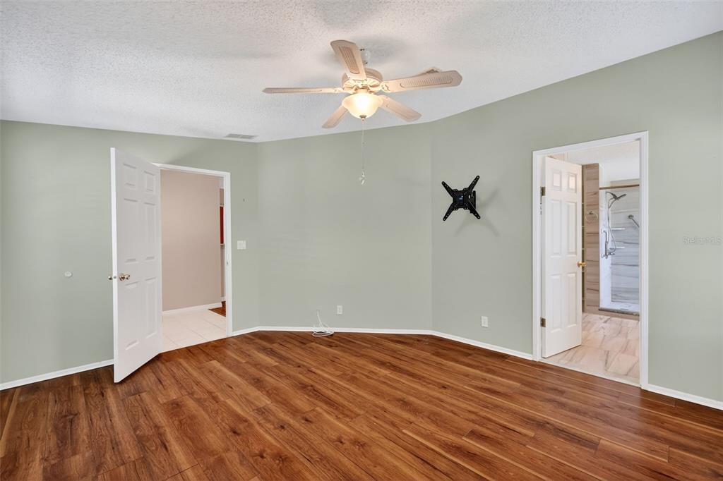3024 Manatee Road Tavares, FL 32778 - Photo 17 of 39 a view of a room with wooden floor and a ceiling fan