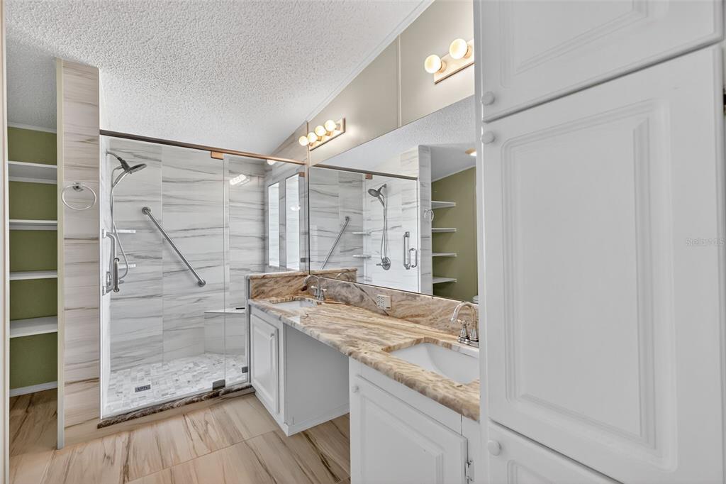 3024 Manatee Road Tavares, FL 32778 - Photo 18 of 39 a bathroom with a granite countertop sink a shower and a mirror