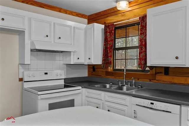 a kitchen with granite countertop white cabinets and white appliances