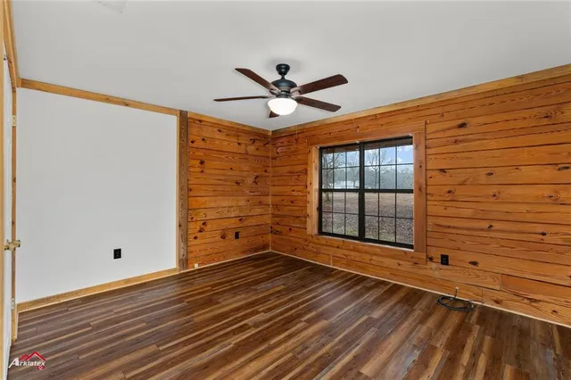 a view of a livingroom with wooden floor and a ceiling fan