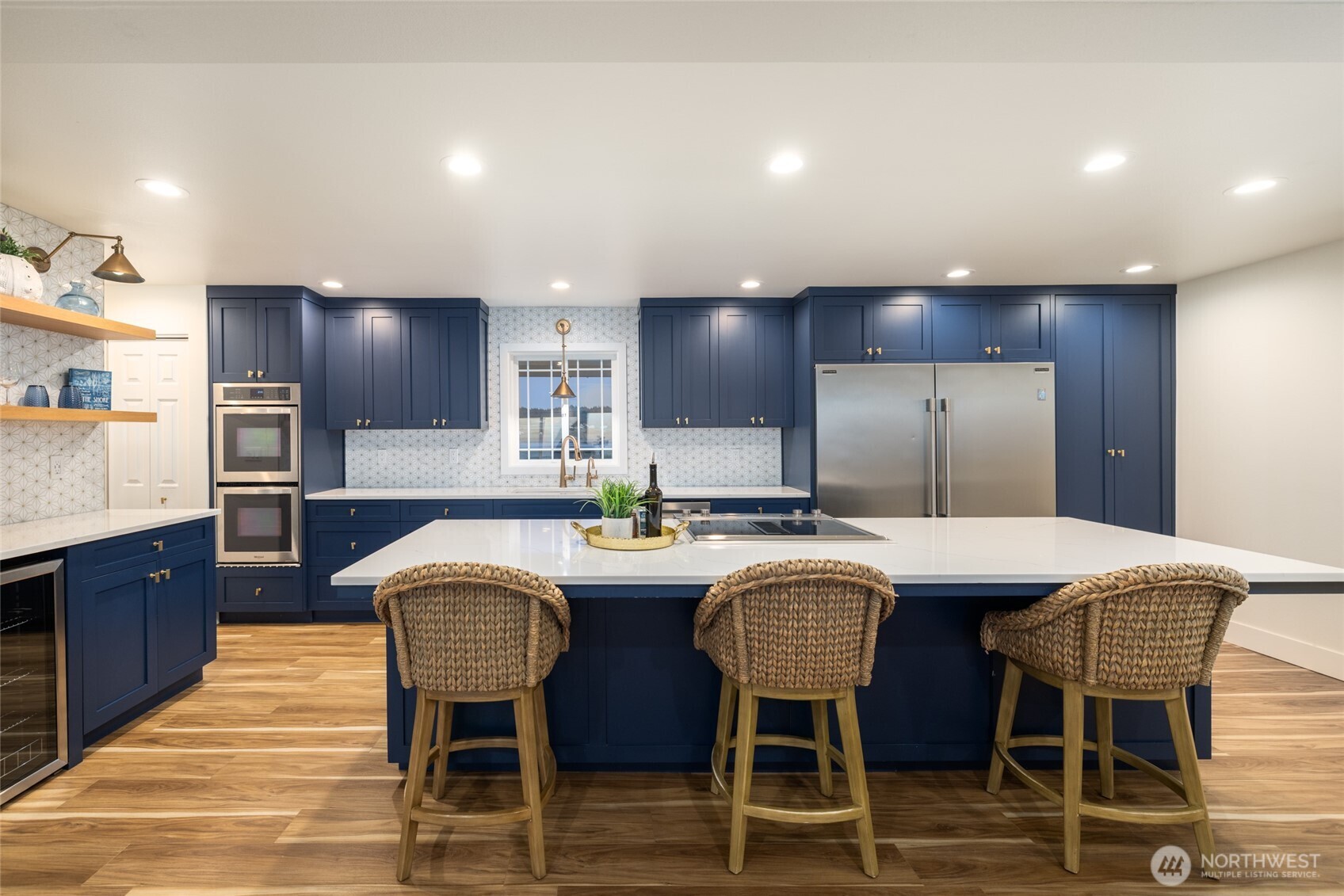 2575 West Beach Road Oak Harbor, WA 98277 - Photo 22 of 40 a large kitchen with granite countertop a dining table chairs wooden cabinets and stainless steel appliances