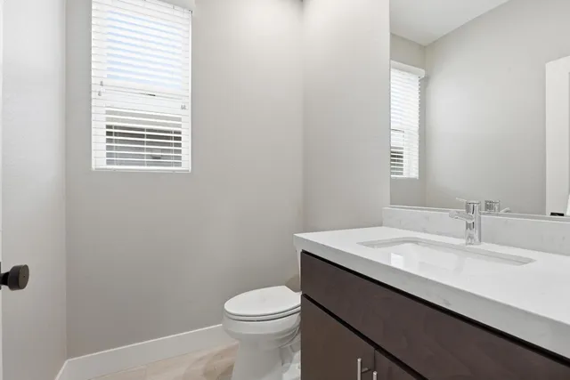 a bathroom with a sink a toilet and a window