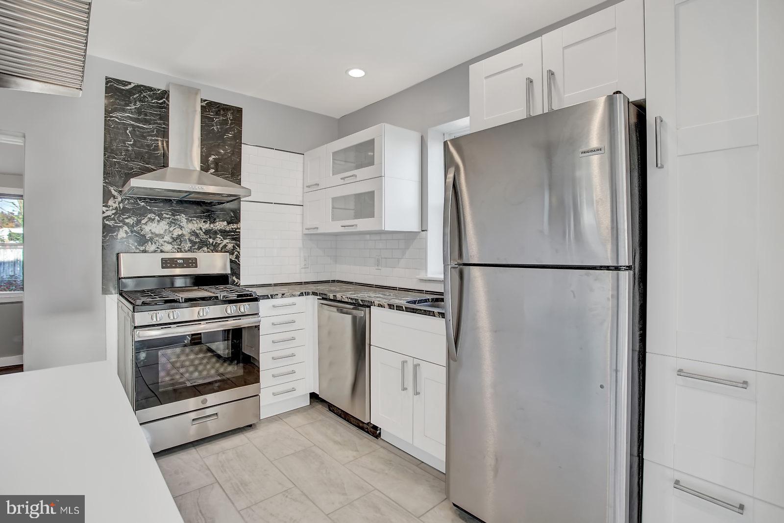 211 South Springfield Road Clifton Heights, PA 19018 - Photo 12 of 24 a kitchen with stainless steel appliances granite countertop a refrigerator and a stove top oven