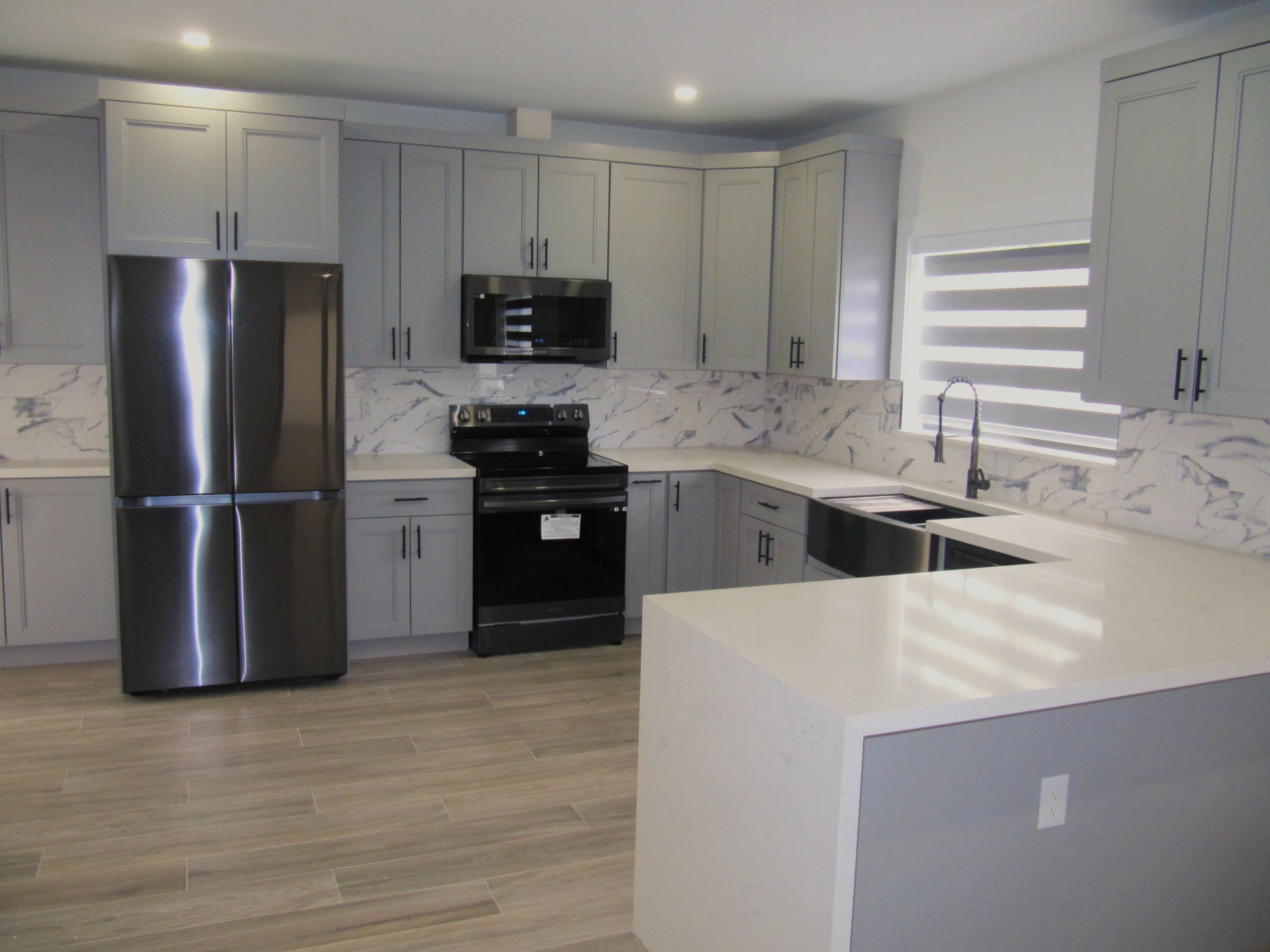 16 Tina Place Key Largo, FL 33037 - Photo 6 of 19 a kitchen with stainless steel appliances granite countertop a refrigerator a stove a sink and a microwave