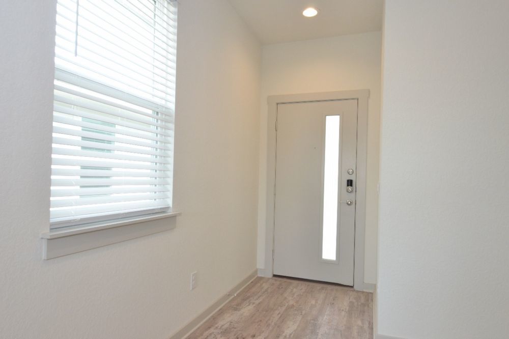 428 Agave Azul Way Leander, TX 78641 - Photo 5 of 24 A welcoming entryway features durable wood-look flooring and a contemporary front door.