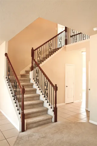 a view of staircase with railing and white walls