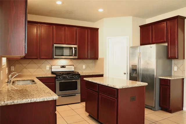 a kitchen with a sink refrigerator and cabinets
