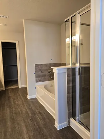 a bathroom with a tub shower and sink