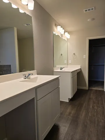 a bathroom with a sink double vanity granite and a mirror