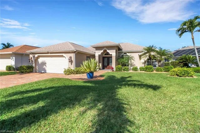 a front view of a house with a yard and potted plants